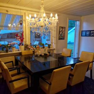 mesa de comedor con sillas y lámpara de araña en Cozy Caravan With House Access! en Luleå