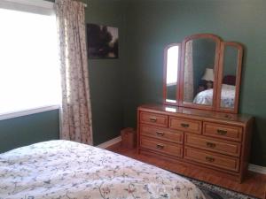 a bedroom with a dresser with a mirror on it at Grumpy's Suite by the Lake in Summerland