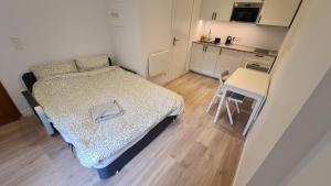 a small bedroom with a bed and a table at Les Bossons Studio in Chamonix