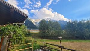 a field with a fence and mountains in the background at Les Bossons Studio in Chamonix