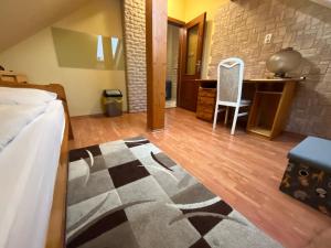 een slaapkamer met een bed en een bureau met een stoel bij Orsi House in Szombathely
