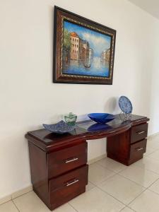 a wooden desk with a painting hanging on a wall at Apartamentos LC cerca de la playa in La Romana