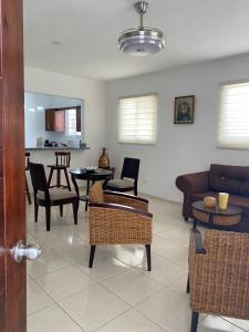 een woonkamer met een bank, stoelen en een tafel bij Apartamentos LC cerca de la playa in La Romana