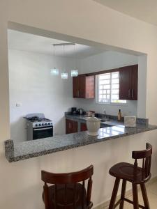 cocina con encimera y 2 taburetes en Apartamentos LC cerca de la playa en La Romana