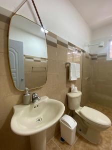 y baño con lavabo, aseo y espejo. en Apartamentos LC cerca de la playa en La Romana