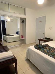 Habitación de hotel con 2 camas y espejo en Apartamentos LC cerca de la playa en La Romana