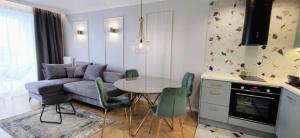 a kitchen and living room with a table and chairs at Apartamenty Baltic Sea Westin House 404 in Kołobrzeg
