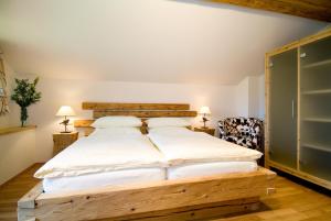 um quarto com uma cama de madeira e 2 cadeiras em Das Bäckergut am Haldensee em Haldensee