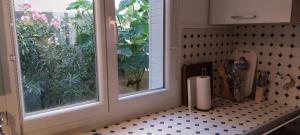 a kitchen with a window and a black and white floor at Au fil de l'eau in Avignon