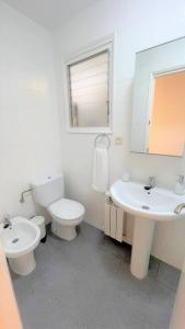 een witte badkamer met een toilet en een wastafel bij Sueños de Mar in Pineda de Mar