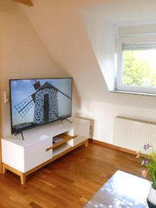 een woonkamer met een flatscreen-tv op een witte kast bij Wohnung mit Stil in Troisdorf
