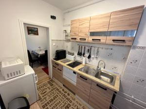 a kitchen with wooden cabinets and a sink at Orsi House in Szombathely