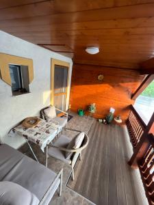 Habitación con terraza de madera con mesa y sillas. en Orsi House, en Szombathely