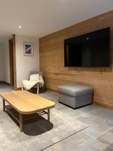 a living room with a large flat screen tv on a wall at Chalet Soleya in Le Grand-Bornand