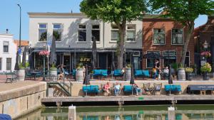 grupa ludzi siedzących w fotelach nad wodą w obiekcie Het Dirkbosje w mieście Middelharnis