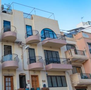 a building with balconies on the side of it at Sea-View Studio Apartment - Sleeps 2 in Marsaskala +4 photos