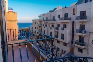 a balcony of a building with a view of the ocean at Sea-View Studio Apartment - Sleeps 2 in Marsaskala