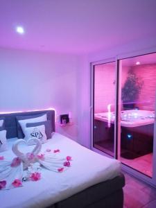 Una habitación púrpura con una cama con flores. en O spa de Caudry, en Caudry