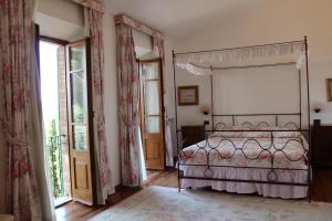 a bedroom with a bed and a large window at Villa Agostoli in Siena