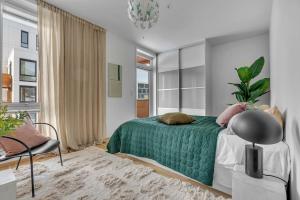 a bedroom with a bed with a green blanket at Seaside city appartment in Tromsø