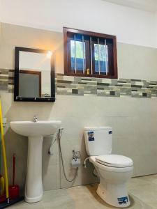 a bathroom with a toilet and a sink at Thanu Villa in Unawatuna