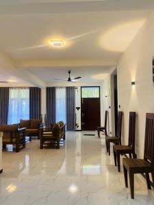 a living room with couches and chairs and a ceiling at Thanu Villa in Unawatuna