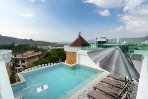 a swimming pool on the roof of a building with an umbrella at Castle Patong amazing private pool villa in great Location of Patong in Patong Beach
