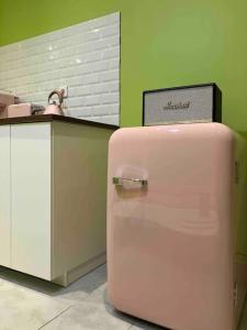 a pink refrigerator sitting next to a counter at Appartement Ibiz’Arles in Arles
