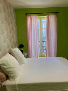a bedroom with a white bed with a window at Appartement Ibiz’Arles in Arles