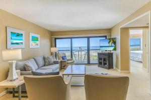 a living room with a couch and a tv at Amelia Island Oceanfront 2 Master Suites in Amelia Island