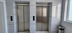 two elevator doors in a bathroom with marble walls at Superb 1 bedroom in the best zone of the city. in Ferizaj
