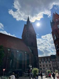una iglesia con una torre de reloj en una ciudad en City Appartement 2 Hannover Altstadt, en Hannover