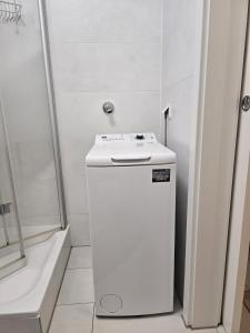 a white refrigerator in a bathroom next to a shower at City Appartement 2 Hannover Altstadt in Hannover