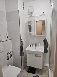 a white bathroom with a sink and a shower at City Appartement 2 Hannover Altstadt in Hannover