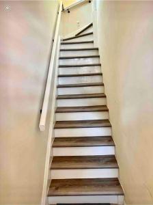 uma escadaria com piso branco e degraus de madeira em 0-A Diamond in Yonkers, NY em Yonkers