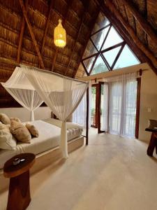 a bedroom with a bed with a mosquito net at Lodge Tzunum Jade in Tulum