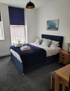 a bedroom with a large bed with a blue headboard at Contemporary 1 Bed Apartment, In Central Buxton in Buxton