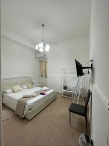 ein weißes Schlafzimmer mit einem Bett und einem Stuhl in der Unterkunft WHITEHOUSE in Lecce