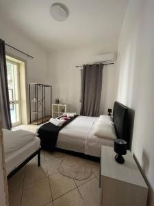 1 Schlafzimmer mit 2 Betten und einem Flachbild-TV in der Unterkunft WHITEHOUSE in Lecce