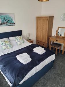 a bedroom with a bed with towels on it at Contemporary 1 Bed Apartment, In Central Buxton in Buxton