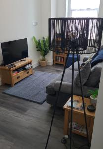 a living room with a couch and a flat screen tv at Contemporary 1 Bed Apartment, In Central Buxton in Buxton