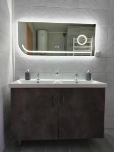 a bathroom with a sink and a mirror at IKONIJA guest house in Pečenjevce +22 photos