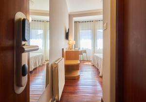 a hallway with two beds and a desk in a room at Hotel Prado Viejo in Moaña