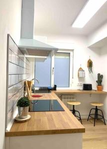 una cocina con encimera con taburetes. en Ubicación Inmejorable Nuevo Céntrico 3Hab, en Oviedo