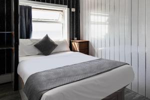1 dormitorio con cama blanca y ventana en OYO Harlands Hotel en Blackpool