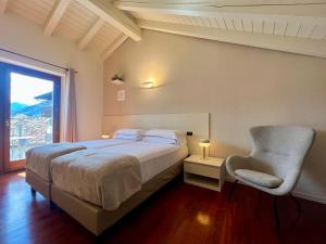 a bedroom with a bed and a chair and a window at DIMORA VERGER in Aosta