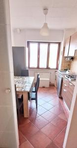 Appartamento Aris في مونفالكوني: مطبخ مع طاولة وكراسي في غرفة
