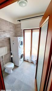 uma casa de banho com uma máquina de lavar roupa e um WC em Appartamento Aris em Monfalcone