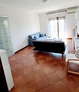 ein Wohnzimmer mit einem Sofa und einem Tisch in der Unterkunft Appartamento Aris in Monfalcone