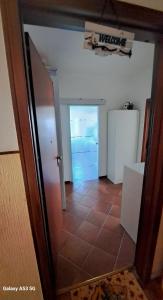 a hallway with a door and a refrigerator in a room at Appartamento Aris in Monfalcone